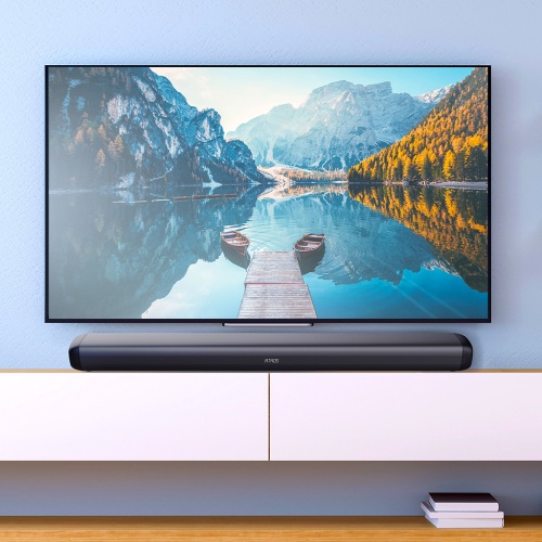 Štýlová obývacia izba s panoramatickým výhľadom na horskú krajinu na TV a TESLA PrimeSound HQ-990 soundbarom pod ním.