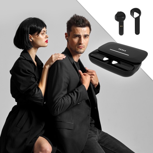 Elegantne oblečený pár, muž a žena, muž sa pozerá do kamery a žena šepká mužovi do ucha, obaja majú v ušiach Tesla Sound EB20 bezdrôtové Bluetooth slúchadlá Black Raven.
