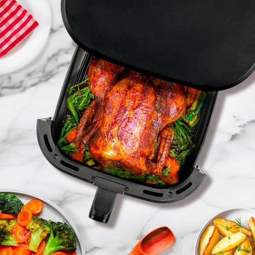 Celé pečené kura pripravené v teplovzdušnom fritovacom hrnci TESLA AirCook Q60 XXL Pro, obklopené zeleninou, zobrazené pri otvorenom koši. Moderná príprava jedla s fritovacím hrncom TESLA.